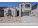 Two-story home features neutral stucco, tiled roof, arched window, and two-car garage with a paved driveway at 21276 W Mariposa St, Buckeye, AZ 85396