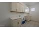 Well-organized laundry room with ample cabinet space, a patterned floor and modern appliances hookups at 21276 W Mariposa St, Buckeye, AZ 85396