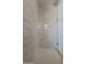 Modern shower featuring neutral-toned tiled walls, glass door, and sleek fixtures at 21276 W Mariposa St, Buckeye, AZ 85396