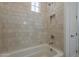 Close-up of the tile shower featuring a bathtub with a showerhead, tiled walls, and a window at 21276 W Mariposa St, Buckeye, AZ 85396