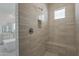 Modern shower featuring neutral-toned tiled walls, built in shelf, and a comfortable bench at 21276 W Mariposa St, Buckeye, AZ 85396