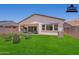 Spacious backyard featuring lush green grass, comfortable seating under a covered patio, and mountain views at 21427 W Meadowbrook Ave, Buckeye, AZ 85396