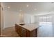 Modern kitchen island featuring a sink, quartz countertop, and stainless steel appliances at 21427 W Meadowbrook Ave, Buckeye, AZ 85396
