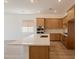 Kitchen features wood cabinets, quartz countertops, stainless steel appliances, and an island with a sink at 21427 W Meadowbrook Ave, Buckeye, AZ 85396