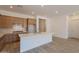 Bright kitchen features wood cabinets, a large island with quartz countertops, and a subway tile backsplash at 21427 W Meadowbrook Ave, Buckeye, AZ 85396