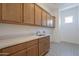 Laundry room with ample cabinet storage and patterned tile flooring at 21427 W Meadowbrook Ave, Buckeye, AZ 85396