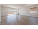 Bright living room featuring wood-style tile flooring and sliding glass doors to the backyard at 21427 W Meadowbrook Ave, Buckeye, AZ 85396