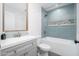 Bathroom featuring a tub and shower with eye-catching blue tile, a white sink and a mirror at 21632 N 48Th St, Phoenix, AZ 85054