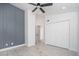 Cozy bedroom offering light wood floor, a ceiling fan, and closet space with doors for storage at 21632 N 48Th St, Phoenix, AZ 85054
