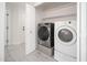Modern laundry room with side-by-side washer and dryer, access door, and upper shelving at 21632 N 48Th St, Phoenix, AZ 85054