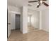 A bedroom featuring an open closet with sliding mirrored doors and light wood flooring at 22547 W Pima St, Buckeye, AZ 85326