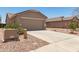View of the home's exterior showcasing the concrete driveway and desert landscaping at 22547 W Pima St, Buckeye, AZ 85326