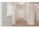 Bright hallway with wood-look flooring and white walls leading to the front door at 22547 W Pima St, Buckeye, AZ 85326