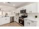 Modern kitchen with stainless steel appliances and white cabinets, open to the living area at 22547 W Pima St, Buckeye, AZ 85326