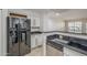 View of the kitchen with black countertops, stainless steel appliances, and white cabinets at 2333 E Southern Ave # 1023, Tempe, AZ 85282