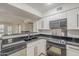 Open kitchen featuring black countertops, white cabinets, and stainless steel appliances at 2333 E Southern Ave # 1023, Tempe, AZ 85282