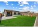 Spacious backyard with artificial grass, covered patio, solar panels, and privacy fencing at 2753 E Fossil Ridge Rd, Phoenix, AZ 85050