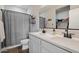 Modern bathroom with dual sinks, white cabinetry, walk-in closet, and a shower-tub combo at 2753 E Fossil Ridge Rd, Phoenix, AZ 85050