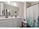 Clean bathroom with double sinks, a large mirror, and a shower-tub combo with a patterned curtain at 2753 E Fossil Ridge Rd, Phoenix, AZ 85050