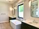 Bathroom featuring a standalone soaking tub, dual vanities and large window at 3021 N 47Th St, Phoenix, AZ 85018
