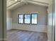 Bright bedroom with vaulted ceilings, light wood floors, and black framed windows overlooking the yard at 3021 N 47Th St, Phoenix, AZ 85018