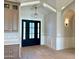 Stylish foyer with white wainscoting, hardwood floors, designer chandelier and a view of the attractive front door at 3021 N 47Th St, Phoenix, AZ 85018