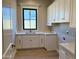 Laundry room featuring white cabinets and quartz countertops, offering both style and function at 3021 N 47Th St, Phoenix, AZ 85018