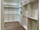Walk-in closet featuring custom white shelving, cabinets, and light wood floors at 3021 N 47Th St, Phoenix, AZ 85018
