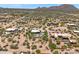 Expansive aerial view of a desert community featuring homes with pools, natural landscapes, and mountain views at 31825 N 141St St, Scottsdale, AZ 85262