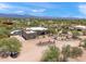 Luxury desert home with a pool surrounded by natural desert vegetation and partly cloudy skies at 31825 N 141St St, Scottsdale, AZ 85262