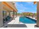 Inviting covered patio area with comfortable seating, overlooking a sparkling pool and beautifully landscaped backyard at 31825 N 141St St, Scottsdale, AZ 85262