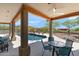 Covered patio showcasing an outdoor seating area with views of the pool, desert landscape, and mountains at 31825 N 141St St, Scottsdale, AZ 85262