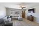 Stylish living room featuring a sectional sofa, ceiling fan, and large window view at 3203 W Libby St, Phoenix, AZ 85053
