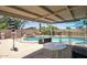 Inviting pool area featuring a covered patio, a charming rock waterfall feature, and a safety fence at 3203 W Libby St, Phoenix, AZ 85053
