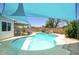 A pristine pool featuring a sunshade, a rock waterfall, and a safety fence, nestled in a private backyard setting at 3203 W Libby St, Phoenix, AZ 85053