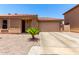Charming single-story home featuring a terracotta roof, desert landscaping, and an attached two-car garage at 3438 S Bowman Rd, Apache Junction, AZ 85119