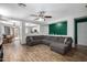 Spacious living room featuring hardwood floors and a large gray sofa with an open view to the kitchen at 3438 S Bowman Rd, Apache Junction, AZ 85119