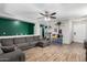 Spacious living room featuring hardwood floors, a gray sofa, and a ceiling fan for enhanced comfort at 3438 S Bowman Rd, Apache Junction, AZ 85119
