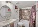 Bright bathroom featuring a stylish vanity, oval mirror, and a bathtub with modern, grey marble-patterned tiling at 3500 N Hayden Rd # 203, Scottsdale, AZ 85251