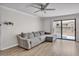 Stylish living room featuring modern ceiling fan, sliding glass doors, and gray sofa at 3500 N Hayden Rd # 203, Scottsdale, AZ 85251