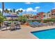 Community pool area with lounge chairs, tables, umbrellas, and grilling stations amidst lush landscaping at 3500 N Hayden Rd # 203, Scottsdale, AZ 85251