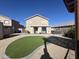 Spacious backyard with artificial turf, covered patio, and a hot tub at 3810 N 106Th Dr, Avondale, AZ 85392