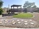 The backyard features gravel landscaping, stepping stones and a pergola at 3810 N 106Th Dr, Avondale, AZ 85392