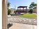 The backyard features gravel landscaping, stepping stones and a pergola at 3810 N 106Th Dr, Avondale, AZ 85392