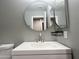 Bathroom vanity with a sink and large round mirror at 3810 N 106Th Dr, Avondale, AZ 85392
