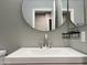 Bathroom vanity with a sink and large round mirror at 3810 N 106Th Dr, Avondale, AZ 85392