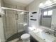 Bright bathroom with granite vanity, toilet, window, and modern, tiled shower with sliding glass doors and handicap bars at 3810 N 106Th Dr, Avondale, AZ 85392