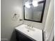 Bathroom vanity featuring a white countertop, dark wood cabinetry, modern fixtures, and stylish tile backsplash at 3810 N 106Th Dr, Avondale, AZ 85392