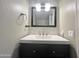 Bathroom vanity featuring a white countertop, dark wood cabinetry, modern fixtures, and stylish tile backsplash at 3810 N 106Th Dr, Avondale, AZ 85392
