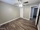 Bedroom featuring ceiling fan, wood-look flooring, and adjacent doorway to the bathroom, creating a seamless transition at 3810 N 106Th Dr, Avondale, AZ 85392